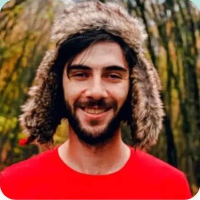 Nico, sonriente, con gorro de pelo y camiseta roja